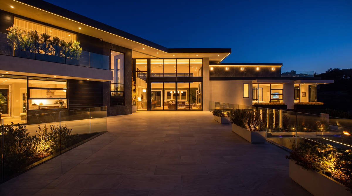 Contemporary luxury home exterior at night with warm layered lighting