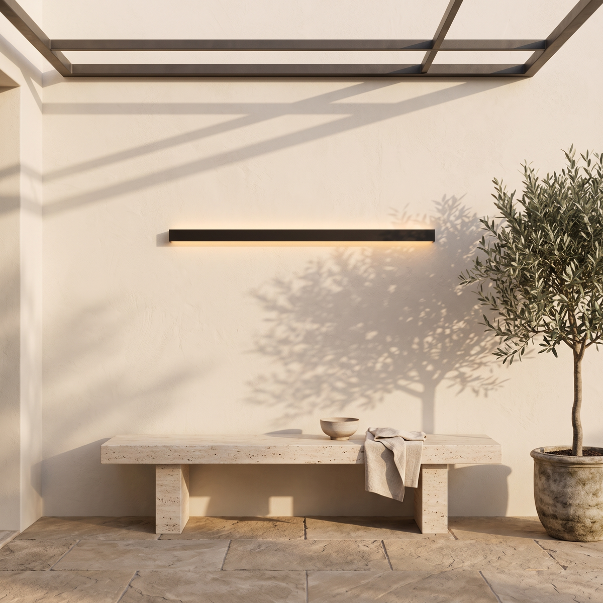 Lumira linear wall light on a courtyard wall above a travertine bench