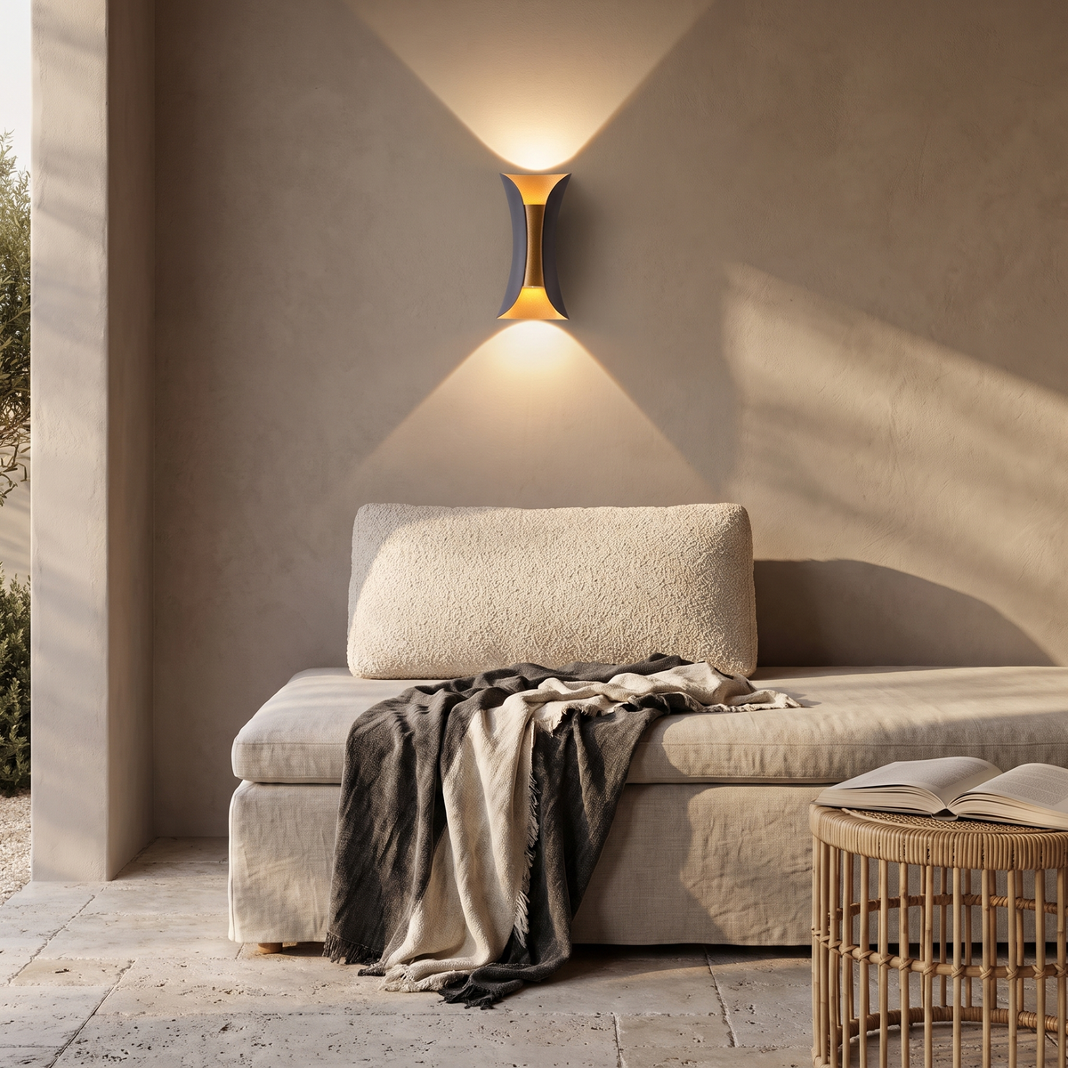 Arcelle sconce above a linen daybed on a covered patio